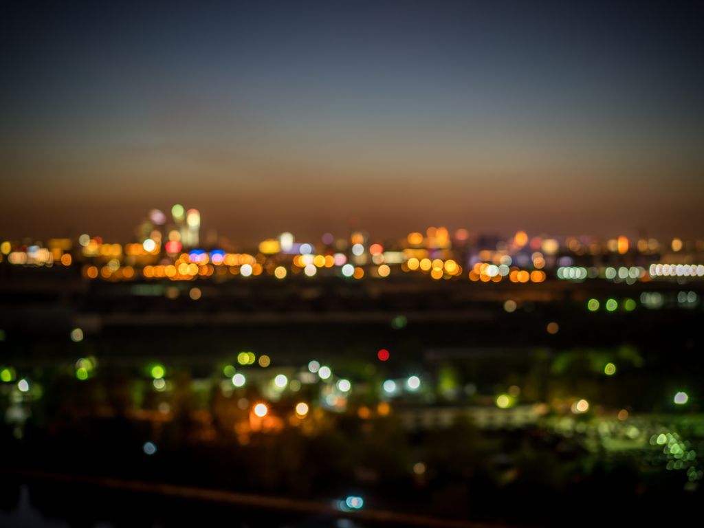 defocused image illuminated city against sky night