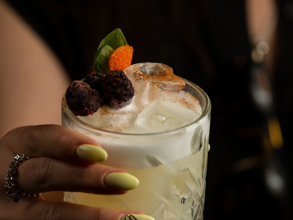 woman holding glass cocktail