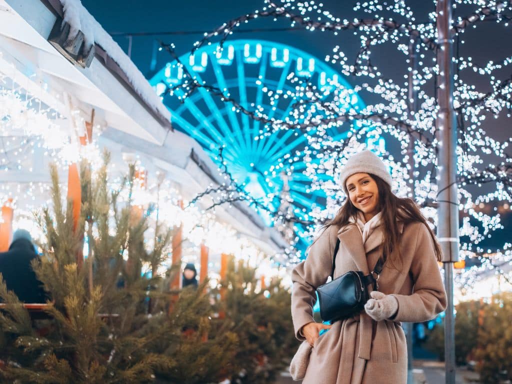 A young woman in front of festive decor.